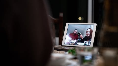 muslimische Familie beim Essen vor Tablet an Ramadan