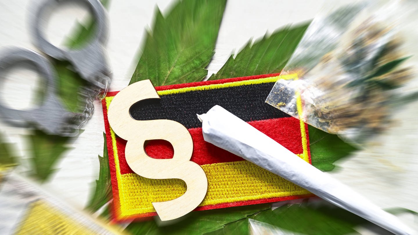 Symbolbild: Joint, Paragrafenzeichen und Deutschland-Fahne auf Cannabis-Blatt mit Handschellen (Foto: IMAGO, Imago images)