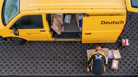Eine Mitarbeiterin von der Deutschen Post DHL belädt ihr Fahrzeug (Foto: dpa Bildfunk, picture alliance/dpa/Jan Woitas)