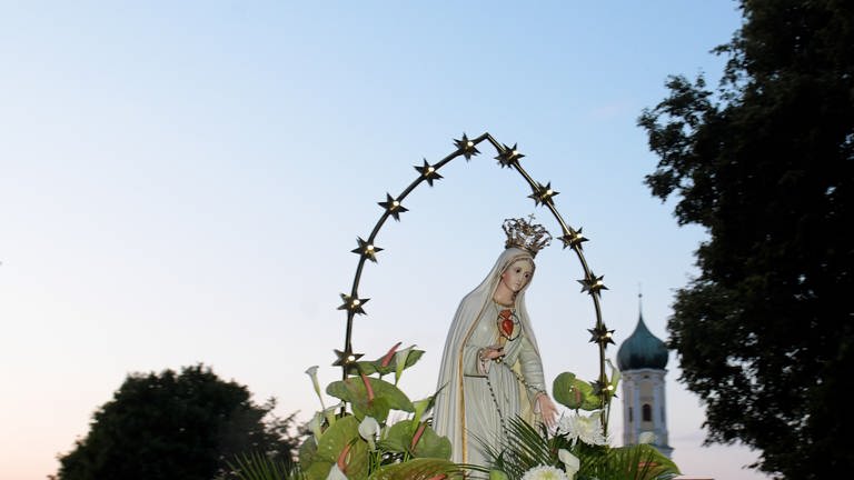 Eine blumengeschmückte Marienstatue wird auf eine Waldlichtung bei der Wallfahrtskirche Maria Vesperbild zu einem Gottesdienst getragen. Die Katholiken vor allem im Süden Bayerns feiern an Mariä Himmelfahrt einen ihrer traditionsreichsten Feiertage (Foto: picture-alliance / Reportdienste, Medien-Nr. 107803877)