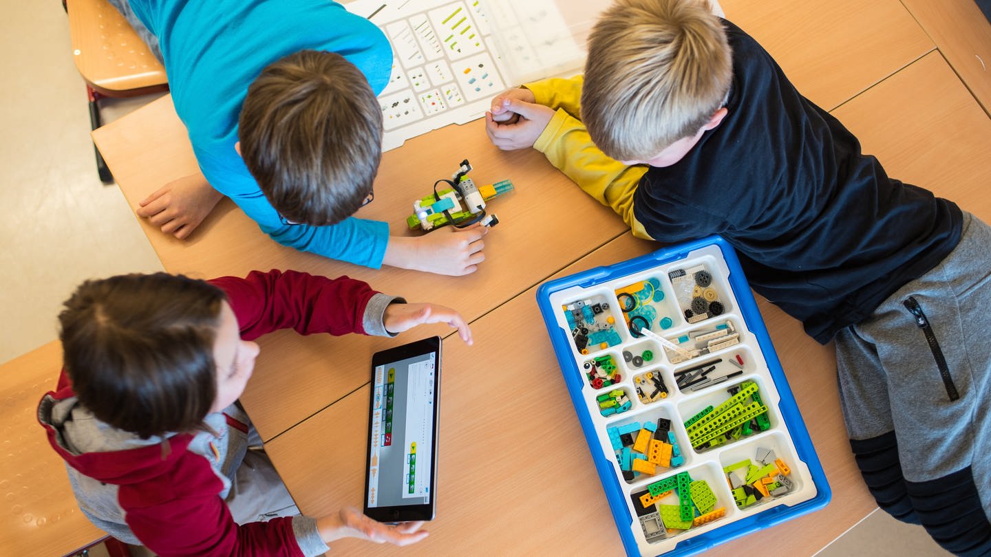Drei Schüler lernen mit dem Tablet-Computer. Rheinland-Pfalz hat sich in einem bundesweiten Vergleich der Bildungssysteme in den vergangenen fünf Jahren vom zehnten auf den siebten Platz der Bundesländer verbessert. (Foto: picture-alliance / Reportdienste, Picture Alliance)