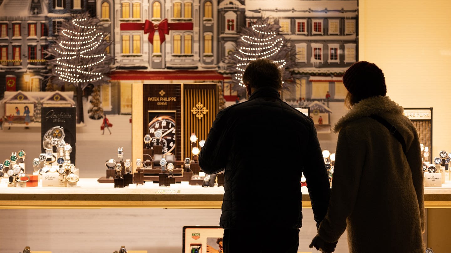 Passanten stehen vor einem weihnachtlich dekorierten Schaufenster. Zum Weihnachtsfest will fast die Hälfte der Bundesbürger einer Umfrage zufolge dieses Jahr sparen. (Foto: picture-alliance / Reportdienste, Picture Alliance)