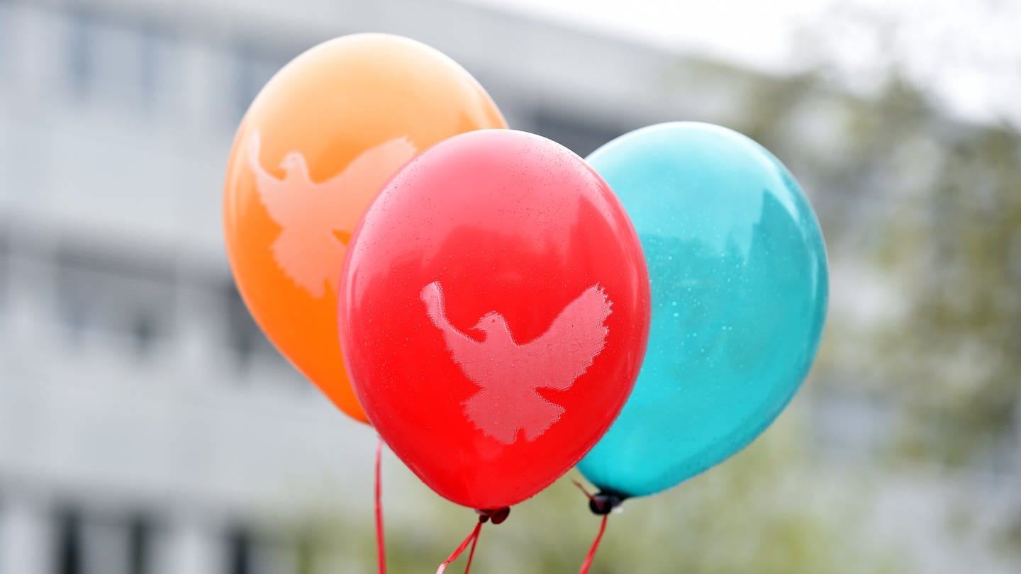 Luftballons mit einer Friedenstaube schweben im Wind. (Foto: dpa Bildfunk, Picture Alliance)