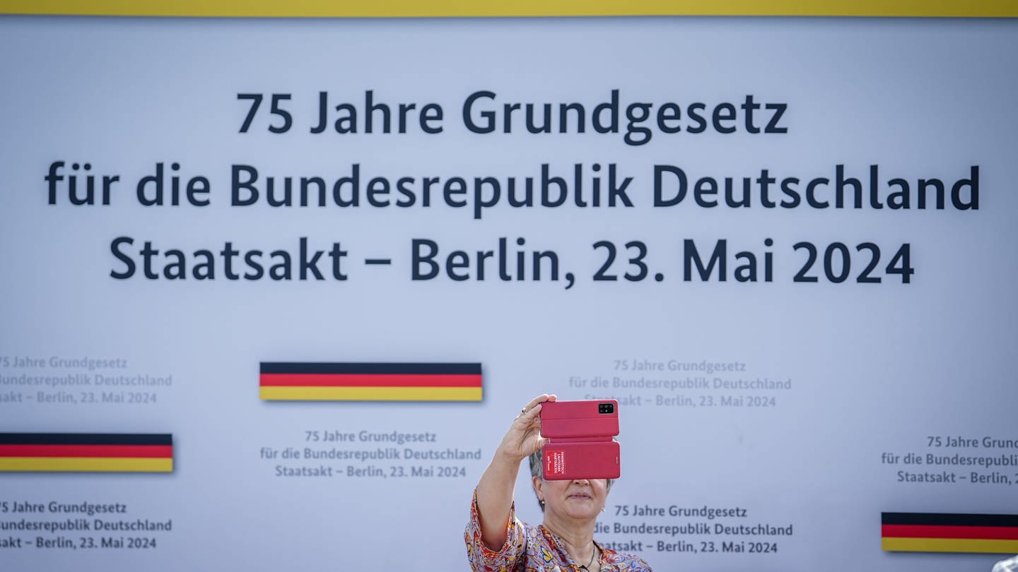Eine Besucherin fotografiert sich beim Staatsakt zu «75 Jahre Grundgesetz» auf dem Forum zwischen Bundestag und Bundeskanzleramt. (Foto: picture-alliance / Reportdienste, Picture Alliance)