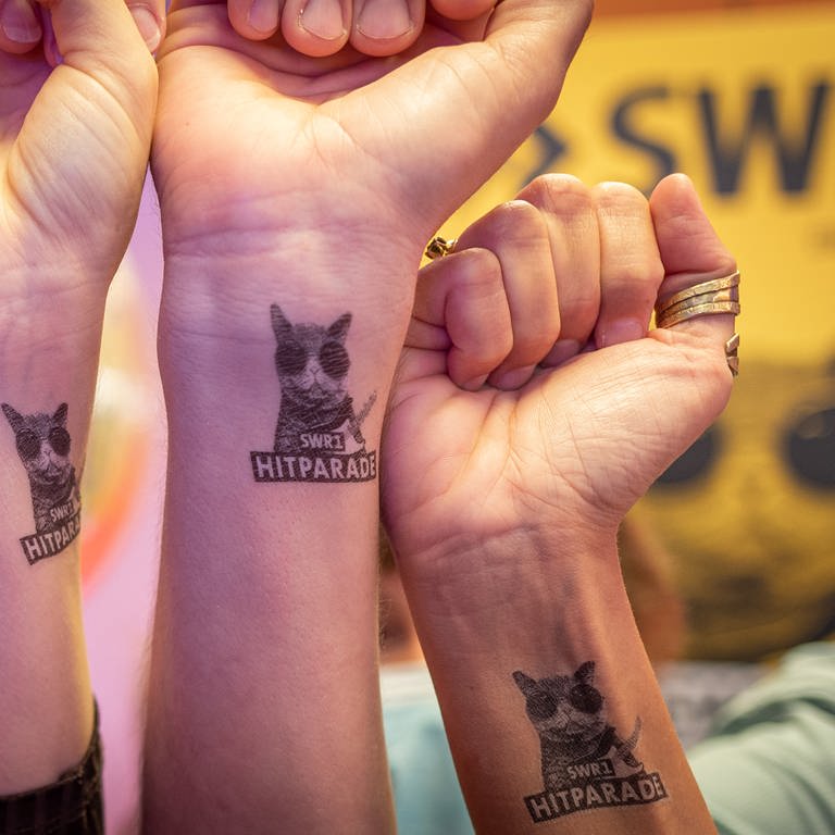 Vier Menschen halten ihre Handgelenke mit einem SWR1 Hitparaden-Tattoo in die Kamera (Foto: SWR)