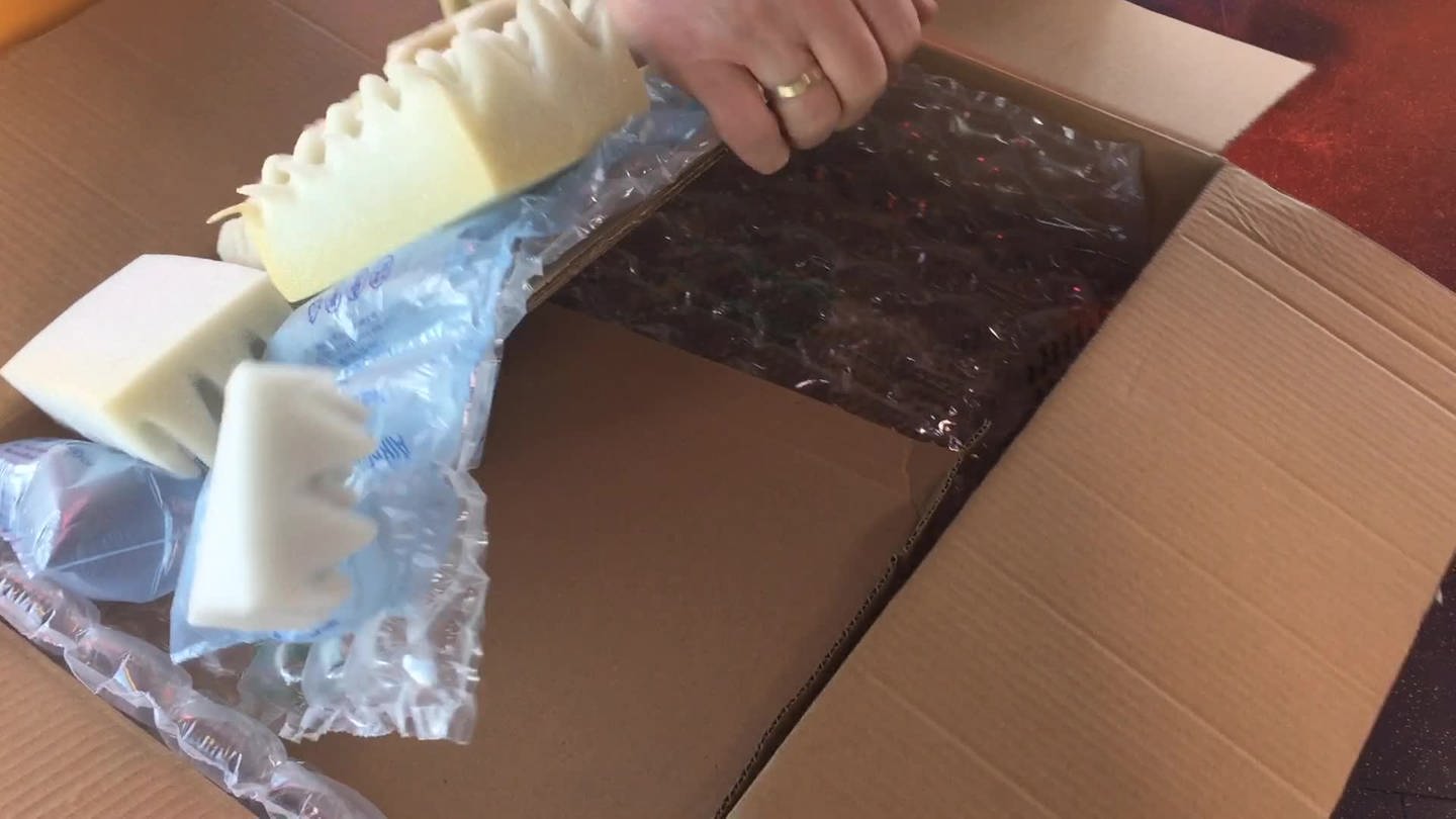 Eine riesige Schokoladentafel wird aus einem Paket ausgepackt. (Foto: SWR)