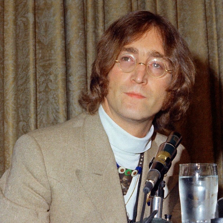 John Lennon in einem grau-beigen Anzug vor einer grau-beigen Gardine (Foto: dpa Bildfunk, picture alliance/dpa)