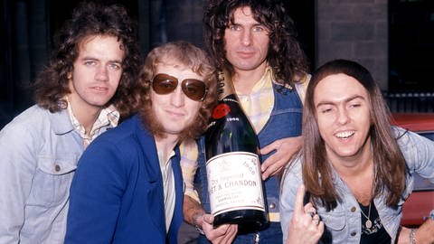 Die Band Slade im Jahr 1973 lächelt mit einer Flasche Sekt in die Kamera. (Foto: picture-alliance / Reportdienste, Picture Alliance)