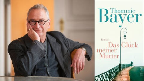 Der Autor Thommie Bayer sitzt an einem Tisch, stützt seinen Kopf auf seine rechte Hand und lächelt in die Kamera (Foto: Peter von Felbert / Piper Verlag)