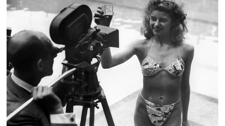 Die Geburtsstunde des modernen Bikini: Micheline Bernardini, eine Nackttänzerin des Pariser Casinos, präsentiert am 5. Juli 1946 in einem Schwimmbad in Paris den ersten Bikini - alle Fashion-Models dieser Zeit hatten es abgelehnt, den Bikini öffentlich zu tragen.  (Foto: picture-alliance / Reportdienste, Picture Alliance)