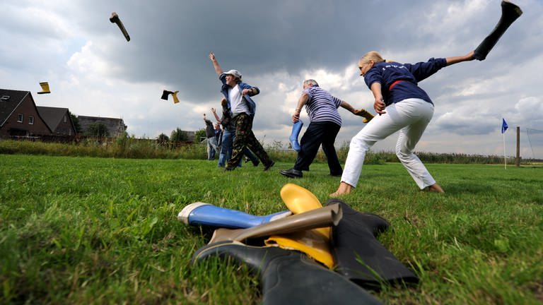 Leute werfen Gummistiefel um die Wette (Foto: picture-alliance / Reportdienste, Angelika Warmuth)