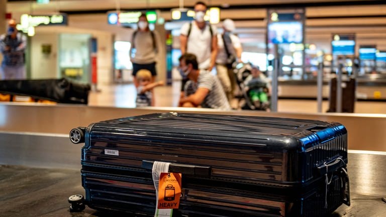 Eine Familie wartet am Gepäckband eines Flughafens auf ihren Koffer. (Foto: picture-alliance / Reportdienste, Picture Alliance)