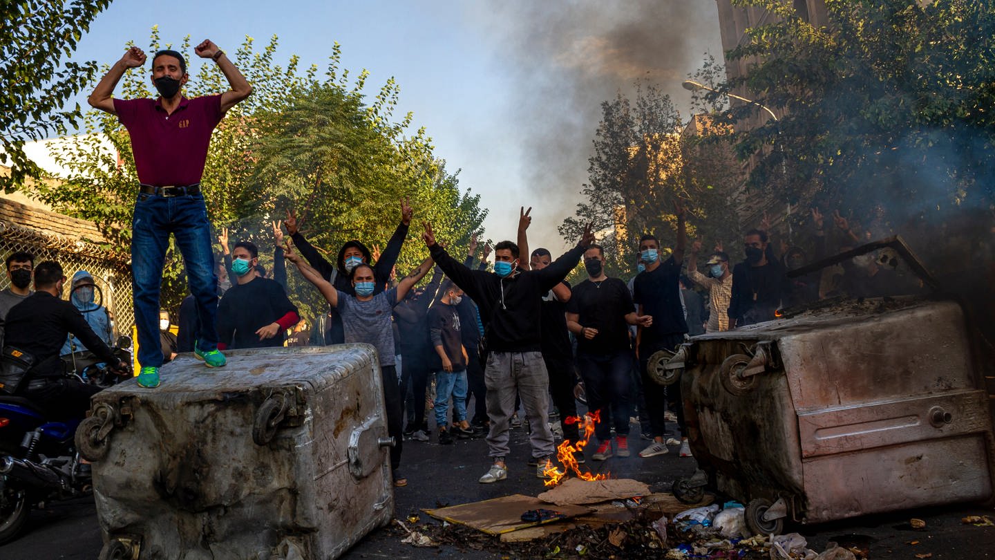 Das Foto zeigt brennende Gegenstände und Iraner, die gegen das Regime protestieren, nach dem Tod der 22-jährigen Mahsa Amini in Haft der Sittenpolizei. (Foto: dpa Bildfunk, picture alliance/dpa/AP | Uncredited)