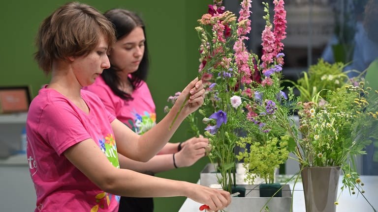 Zwei junge Frauen binden Blumensträuße. In Baden-Württemberg sind viele Ausbildungsstellen unbesetzt. Grund für den Azubimangel ist auch der demografische Wandel. Was wünscht sich die Generation Z von einer Ausbildung?
