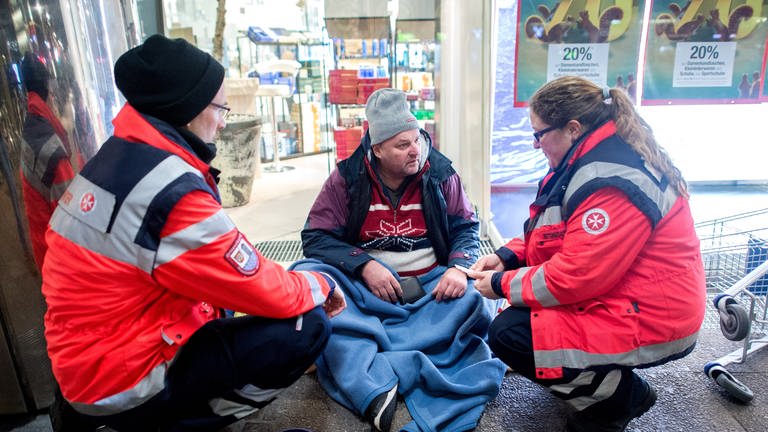 Ehrenamtlichen Helfer mit einem Obdachlosen (Foto: picture-alliance / Reportdienste, picture alliance / Hauke-Christian Dittrich/dpa | Hauke-Christian Dittrich)