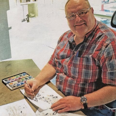 Buchautor Jo-Kurt beim Zeichnen von Cartoons.