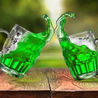 Zwei Bierkrüge gefüllt mit einer grünen alkoholischen Flüssigkeit zur Feier des St. Patricks Day in einem Irish Pub.