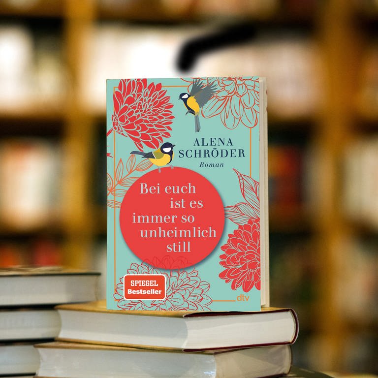 Gewinner SWR1 Lieblingsbuch ist das Buch "Bei euch ist es immer so unheimlich still" von Alena Schröder, dieses steht auf einem Bücherstapel