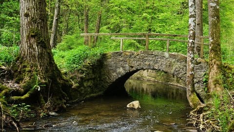 Eine Brücke führt über einen kleinen Bachdurch die sieben Täler