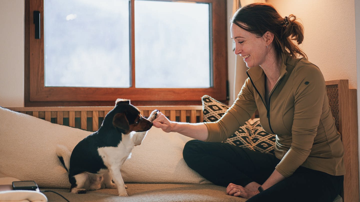 Sophie Lübbert sitzt mit ihrem Jack Russell Terrier Sam auf dem Sofa. Mit ihm hat sie viele Hotels bereist und auf Hundekompatibiltät getestet. Daraus ist der Online-Reiseführer 