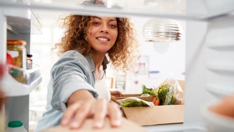 Eine Frau legt Lebensmittel in den Kühlschrank (Foto: Colourbox)