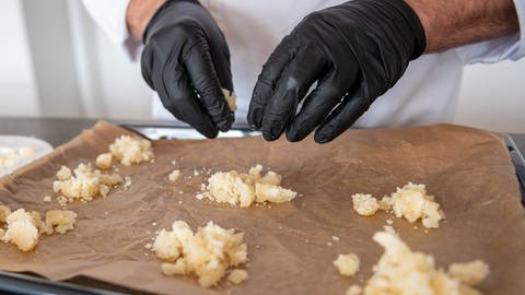 Zerkrümelter Harzer Käse der zu Häufchen auf einem Backblech gesetzt wurde