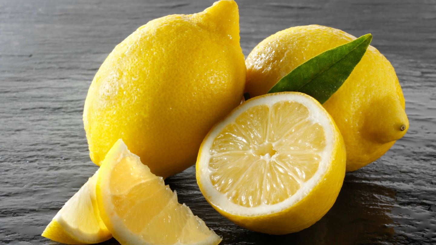 Ganze und aufgeschnittene Zitronen für das Rezept 