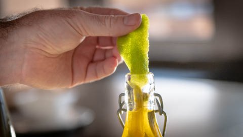 Limettenschalen werden in eine Falsche mit Öl gegeben (Foto: SWR, Jochen Enderlin)
