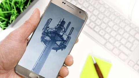 Smartphone zeigt ein Foto von einem Mobilfunksendemast (Foto: IMAGO, Imago/Christian Ohde -)