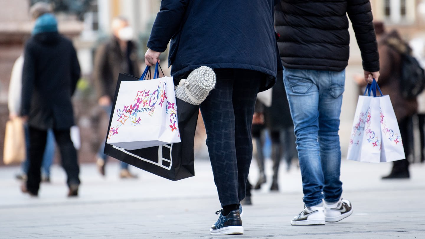 Zwei Männer tragen weihnachtlich verzierte Einkaufstaschen. Ab Mittwoch tritt in Deutschland der harte Lockdown in Kraft, mit dem auch der Einzelhandel in der Innenstadt schließen muss. (Foto: dpa Bildfunk, Picture Alliance)