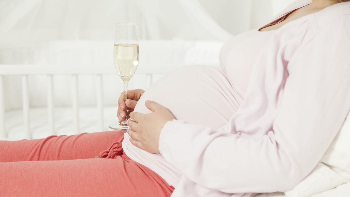 Schwangere Frau mit einem Sektglas am Babybauch. Alkoholkonsum in der Schwangerschaft kann das Fetale Alkoholsyndrom (FASD) auslösen. (Foto: dpa Bildfunk, picture alliance / imageBROKER | BQ)