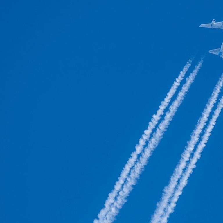 Flugzeug mit Kondensstreifen am Himmel