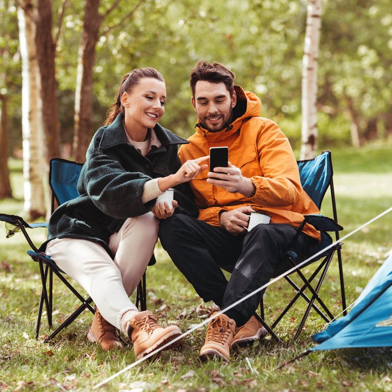Camper sitzen vor Smartphone