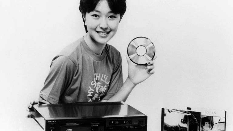 Ein Model präsentiert im September 1982 in Japan die neuesten Produkte der Sony Corporation: den CD-Player CDP-101 und Compact Discs mit einem Durchmesser von 12 Zentimetern, die ab 1. Oktober 1982 in den Handel gehen. (Foto: picture-alliance / Reportdienste, dpa Bildfunk, Picture Alliance/Picture Alliance)