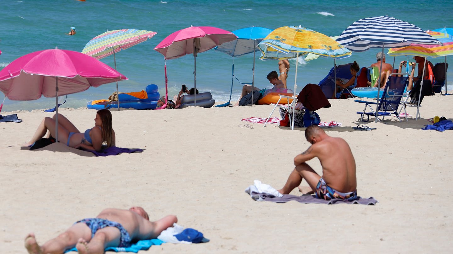 Mallorca: Menschen liegen am Strand (Foto: picture-alliance / Reportdienste, picture alliance/dpa | Clara Margais)