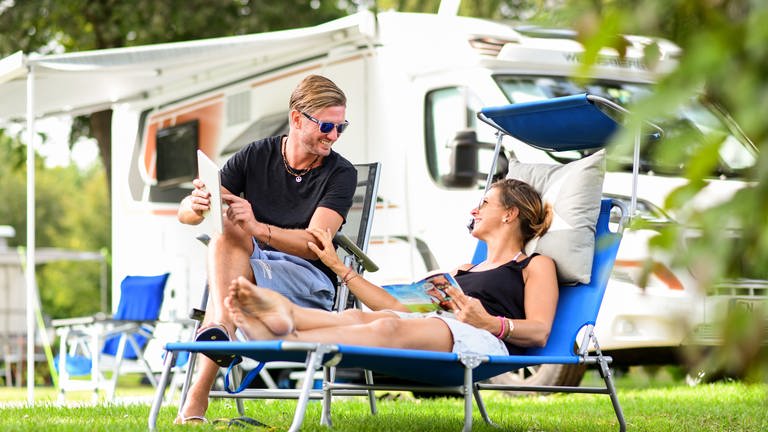 Paar auf Campingplatz | Rabattkarten sparen beim Campen bares Geld