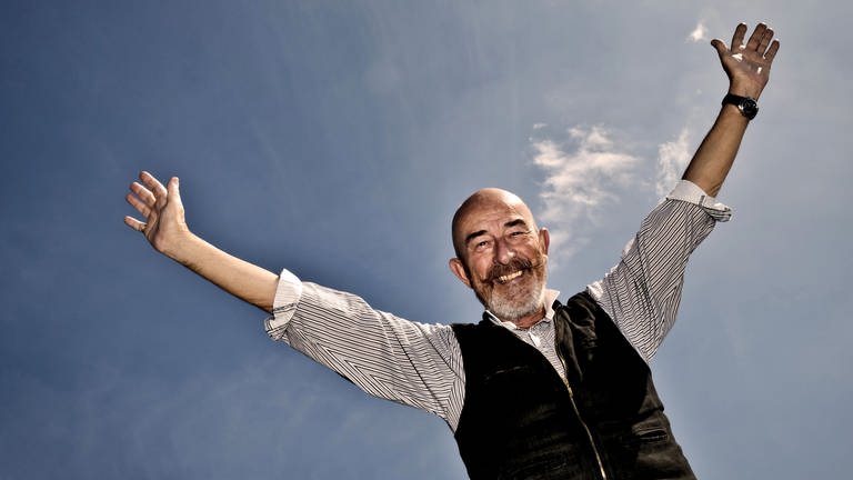Glücklicher Mann vor blauem Himmel  | Tipps zum glücklich sein – auch in schwierigen Zeiten (Foto: dpa Bildfunk, Picture Alliance)