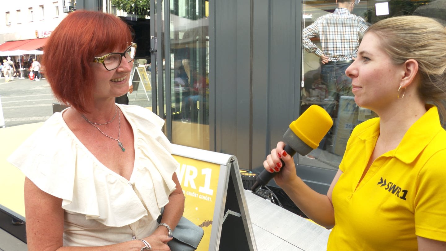 Nina Waßmundt interviewt Hörer und Hörerinnen vor dem Gläsernen Studio bei der SWR1 Hitparade 2023 in Neuwied (Foto: SWR)