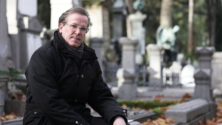 Christoph Kuckelkorn, Bestattungsunternehmer und Karnevalspräsident, sitzt auf dem Melatenfriedhof an Gräbern.  (Foto: dpa Bildfunk, picture alliance/dpa | Oliver Berg)