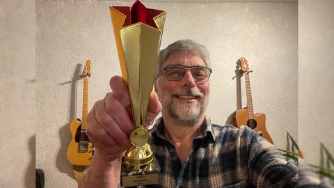 SWR1 Musikredakteur und Meilensteine Podcast Host Frank König mit dem Pokal für den SWR1 Meilensteine Profi. (Foto: SWR, Frank König)