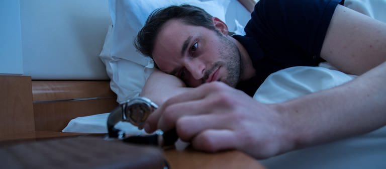 Mann schaut schlaflos auf die Uhr (Foto: picture-alliance / Reportdienste, Picture Alliance)