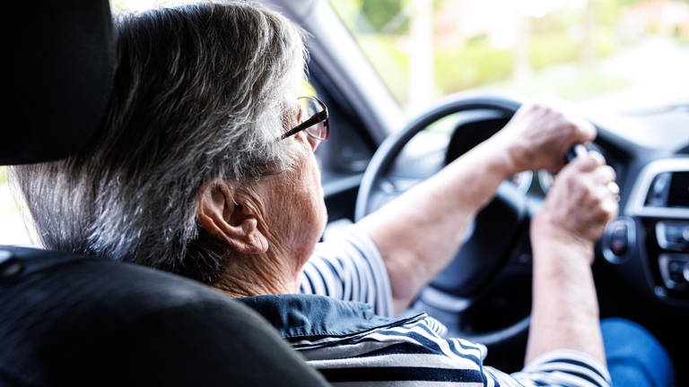 Eine über 90-jährige Frau sitzt hinter dem Lenkrad eines Autos. (Foto: picture-alliance / Reportdienste, picture alliance / Matthias Balk | Matthias Balk)