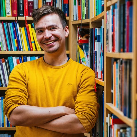 Gymnasiallehrer und Bildungsinfluencer Bob Blume steht lächelnd vor Bücherregalen (Foto: dpa Bildfunk, picture alliance/dpa | Philipp von Ditfurth)