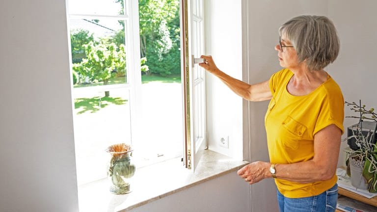 Eine Frau öffnet ein Fenster um die Wohnung zu lüften (Foto: picture-alliance / Reportdienste, picture alliance / dpa-tmn | Benjamin Nolte)