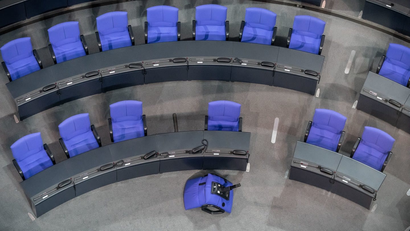 Eine Sitzreihe im Bundestag. Ein Stuhl liegt umgekippt vor der Sitzreihe. Der Bundestag hat über die Wahlrechtsreform abgestimmt. (Foto: picture-alliance / Reportdienste, picture alliance/Michael Kappeler/dpa)