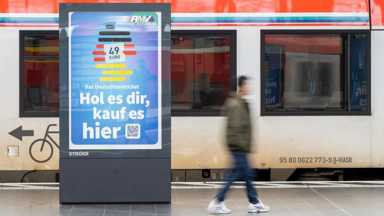 Die Werbung für das Deutschlandticket ist am Hauptbahnhof vor einer Bahn des ÖPNV zu sehen. Seit Montag gilt bundesweit das 49 Euro teure Deutschlandticket im öffentlichen Personennahverkehr. (Foto: picture-alliance / Reportdienste, picture alliance/dpa | Sebastian Gollnow)