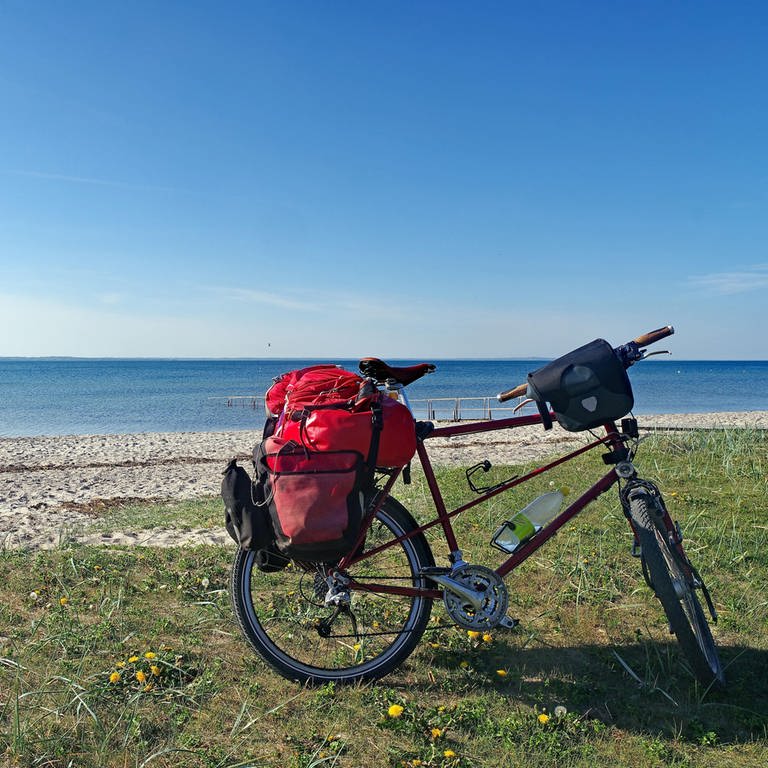 Fahrrad voller Gepäck steht am Strand