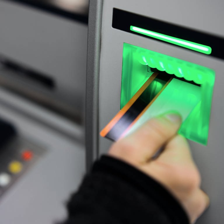 Eine Person steckt Ihre EC-Karte in einen Geldautomat.