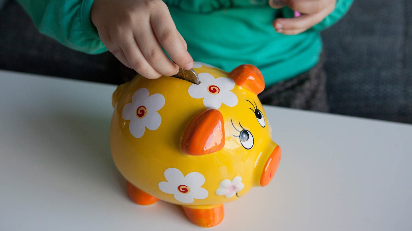 Kind steckt Geld in ein Sparschwein (Foto: picture-alliance / Reportdienste, picture alliance / dpa Themendienst | Silvia Marks)