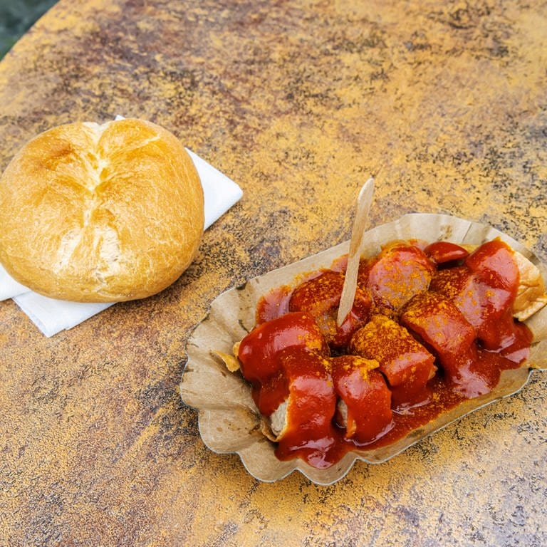 Eine Portion Currywurst liegt auf einem Tisch  (Foto: picture-alliance / Reportdienste, picture alliance / imageBROKER | Arnulf Hettrich)